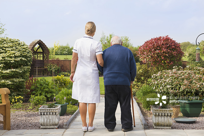 白人护士和病人走在花园里图片素材