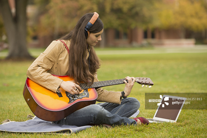 在校园里弹吉他的白人大学生图片素材