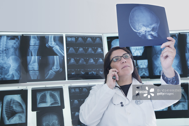 西班牙裔医生在医院检查X光片图片素材