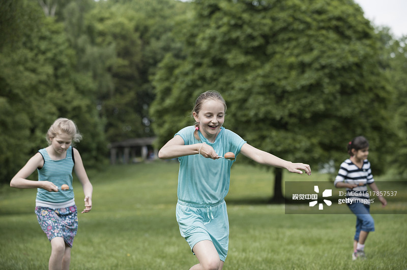 在德国巴伐利亚慕尼黑的一个公园里，一群女孩参加鸡蛋竞跑比赛图片素材