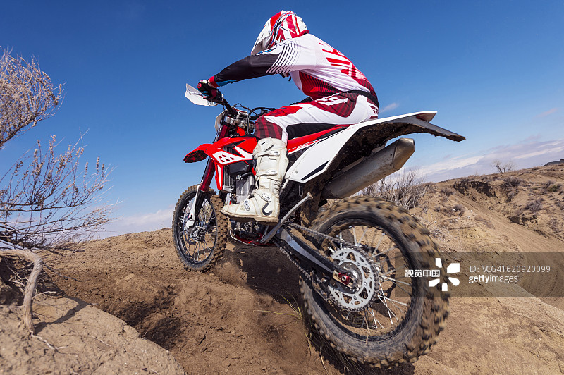 在山坡上骑越野摩托车的摩托车手图片素材