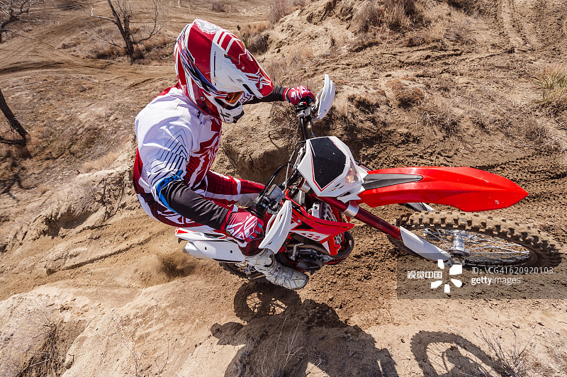 在山坡上骑越野摩托车的摩托车手图片素材
