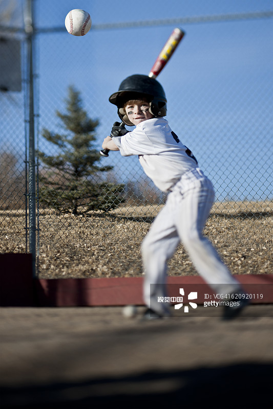 白人男孩在球场上打棒球图片素材