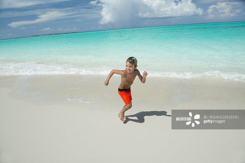 在海滩上奔跑的西班牙裔男孩图片素材