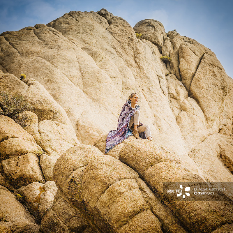 西班牙裔女人坐在岩石上图片素材