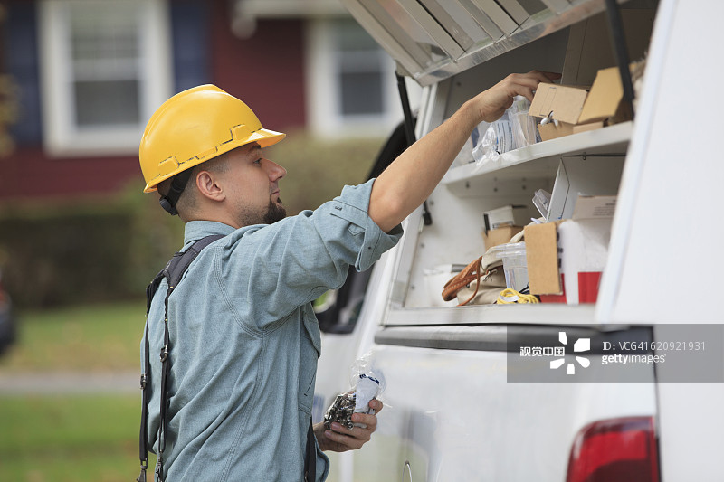 白人工人从卡车上拉设备图片素材
