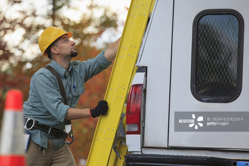 白人工人把梯子装到卡车上图片素材