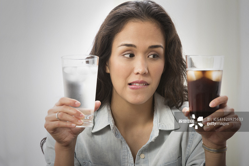 选择苏打水和水的混血女人图片素材