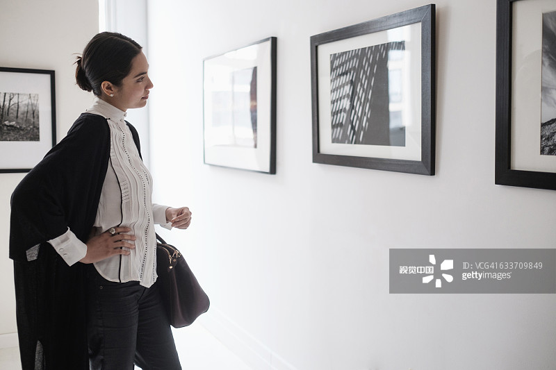 在画廊欣赏艺术品的西班牙裔女性图片素材