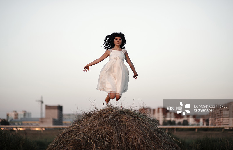 一个白人女人在干草堆上跳图片素材