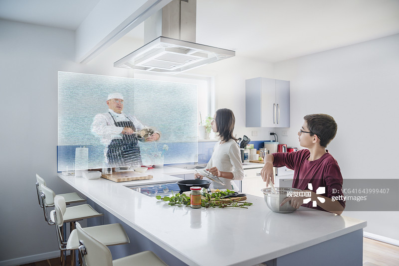 兄妹在厨房观看全息烹饪节目图片素材