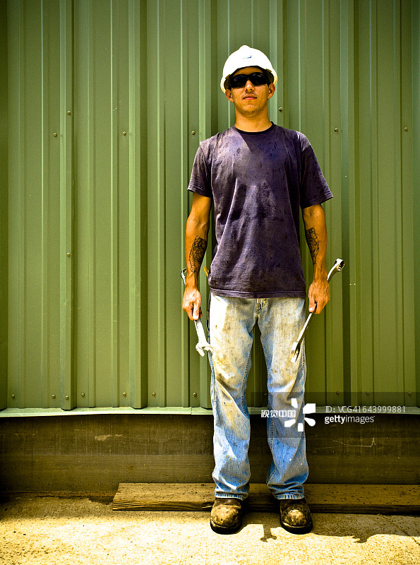 在工地上手持扳手的白人建筑工人图片素材