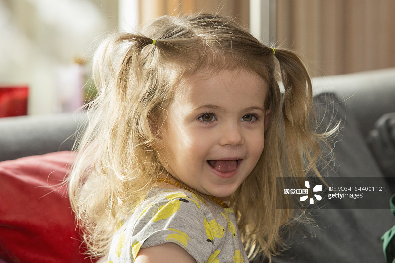 一个在沙发上微笑的白人学龄前女孩图片素材