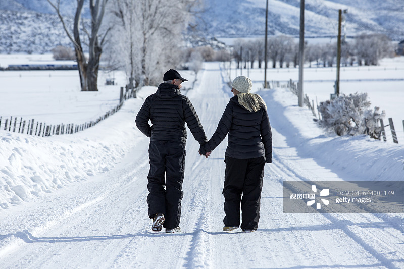 一对白人夫妇走在遥远的雪地上图片素材