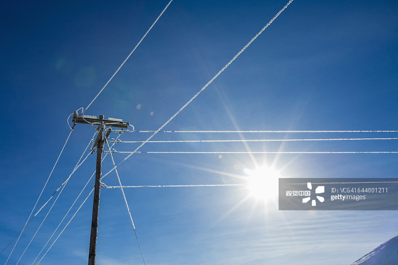蓝天下的阳光和冰冷的电线图片素材
