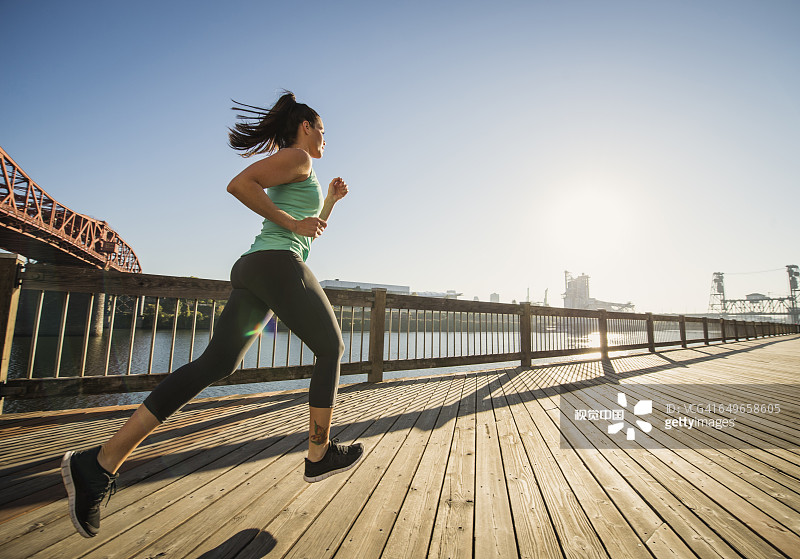 在城市滨水区慢跑的白人女性图片素材