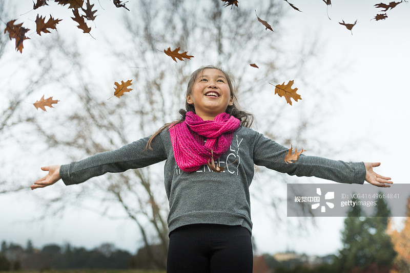 混血女孩在秋叶中嬉戏图片素材