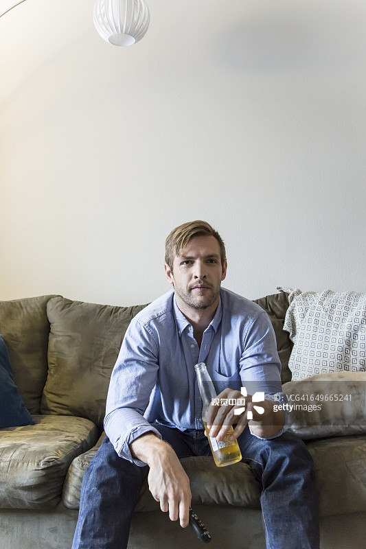 男人在沙发上喝啤酒图片素材