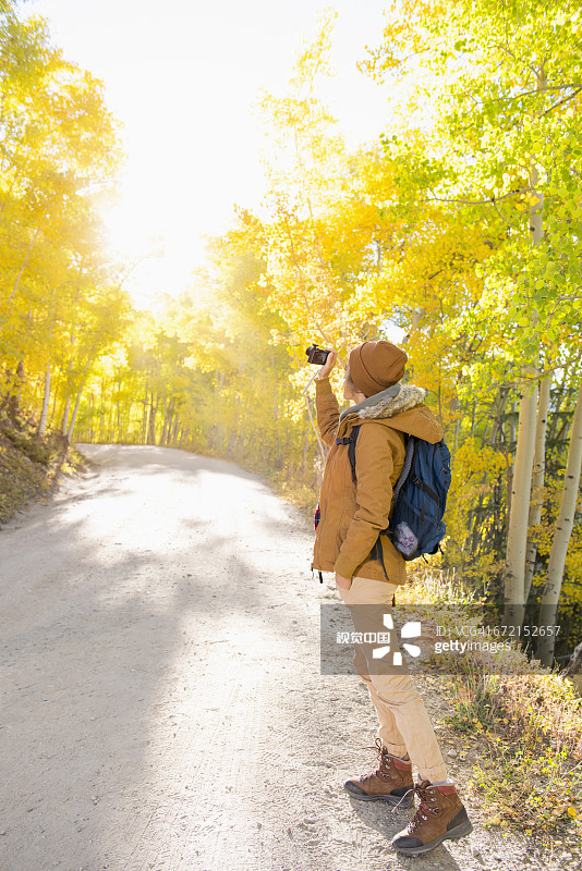 在徒步小路上使用数码相机的拉美裔女人图片素材