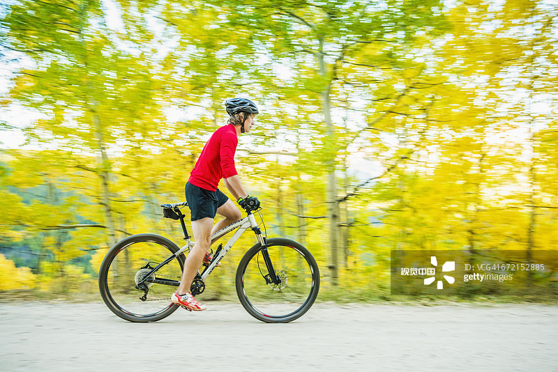 白人男子在森林小路上骑山地自行车图片素材