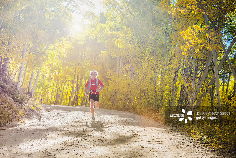 白人男子在森林小路上跑步图片素材