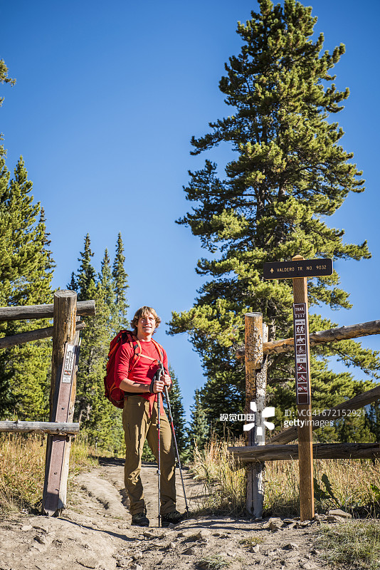 背着背包站在小路入口的白人徒步旅行者图片素材