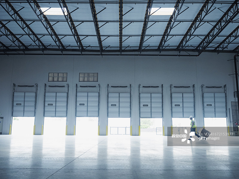 印度工人在开放式装货码头门附近拉手推车图片素材