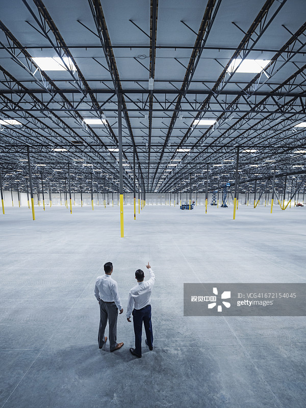 在空旷仓库里交谈的商人图片素材