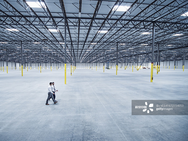 商人在空旷的仓库里行走图片素材