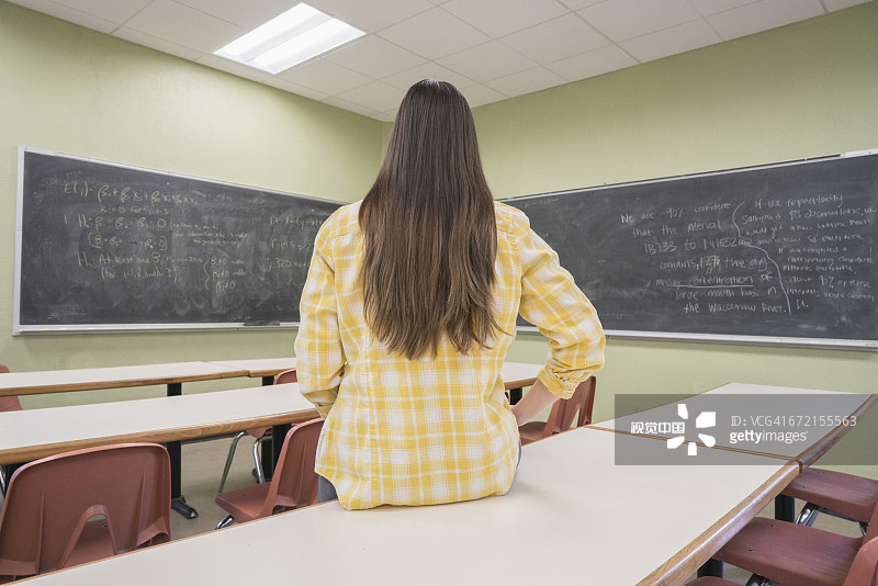 坐在教室桌子上的白人妇女图片素材