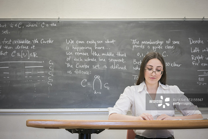 一个白人女人在教室书桌前看书图片素材