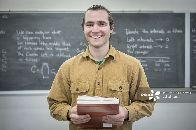 白人男子在教室里拿着教科书图片素材