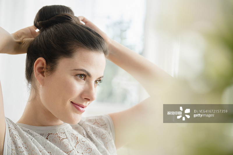 白人妇女正在扎发髻图片素材