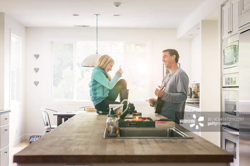白人女孩用手机录制父亲弹吉他图片素材
