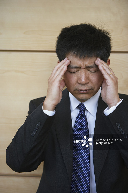 亚洲商人在揉太阳穴图片素材