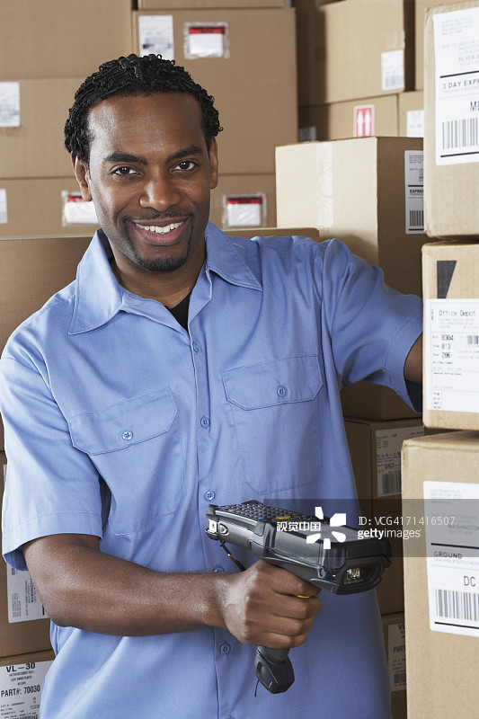 扫描包裹的非洲男性仓库工人图片素材