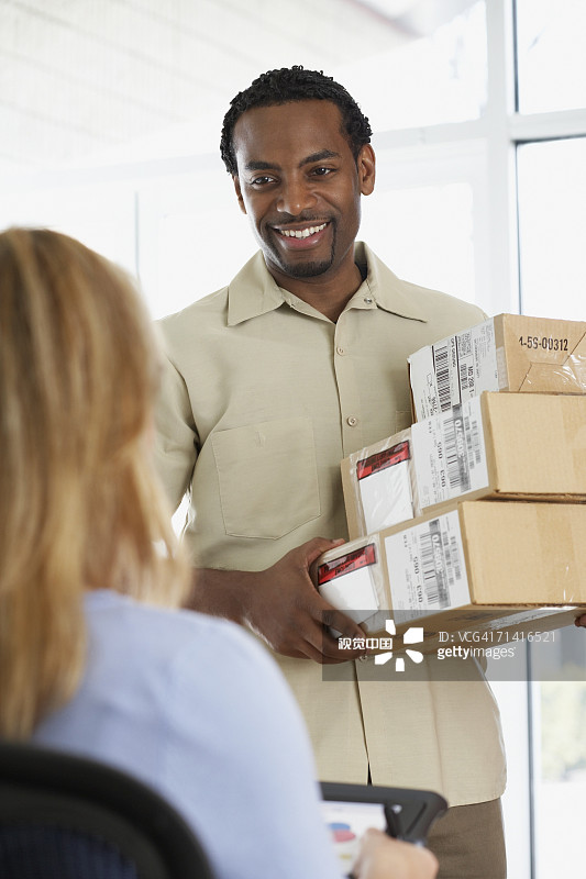 一个女人在为非洲快递员签收包裹图片素材