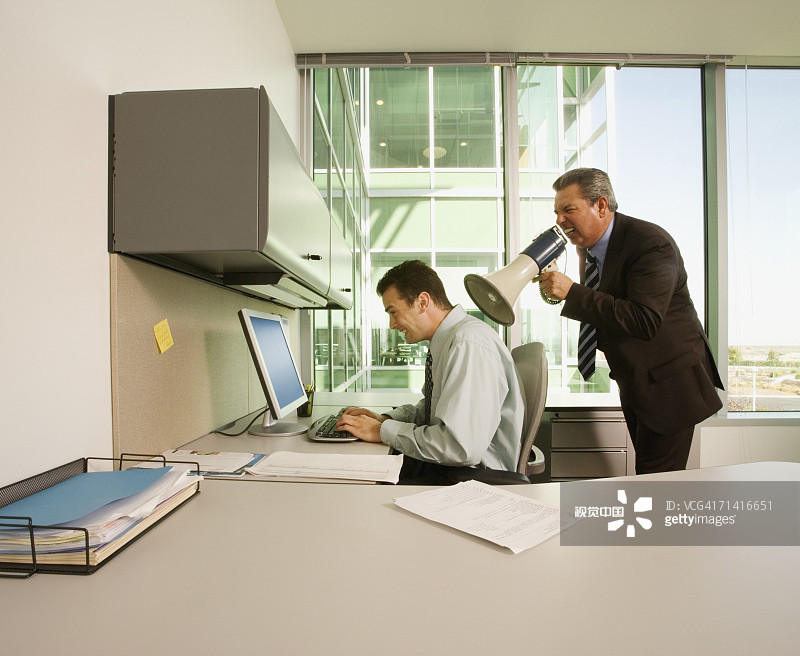 商务男人用扩音器对着同事喊叫图片素材