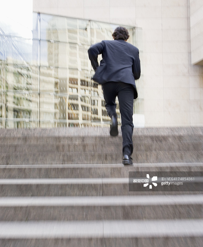 商人跑上办公大楼台阶图片素材