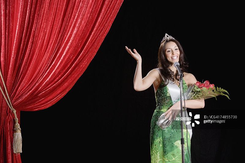 在舞台上挥手的西班牙裔选美比赛获胜者图片素材