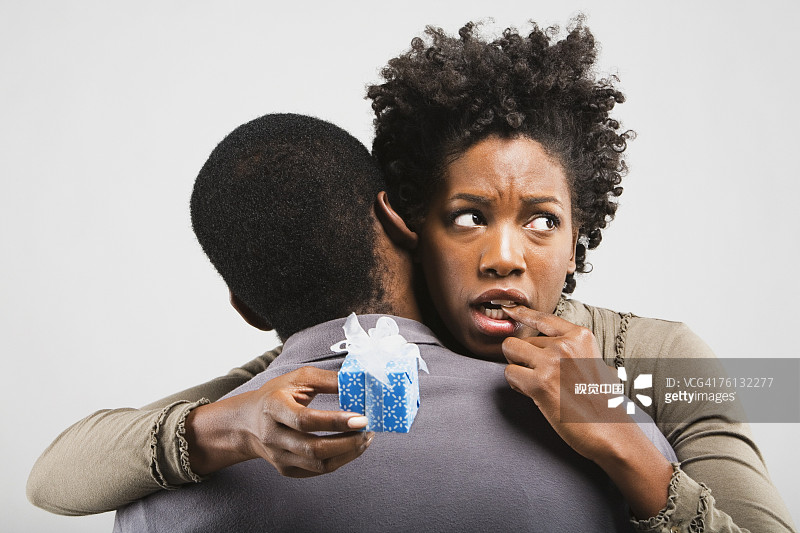 担忧的非裔女人拥抱男友和礼物图片素材