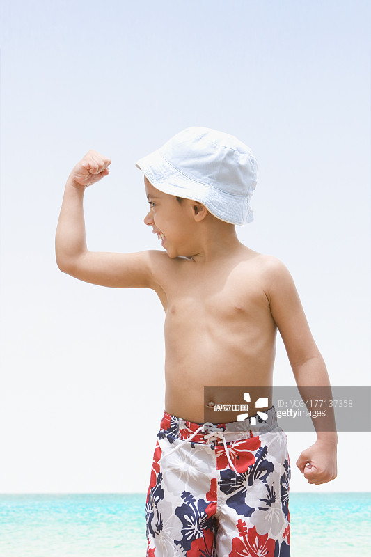 展示肱二头肌的西班牙裔男孩图片素材