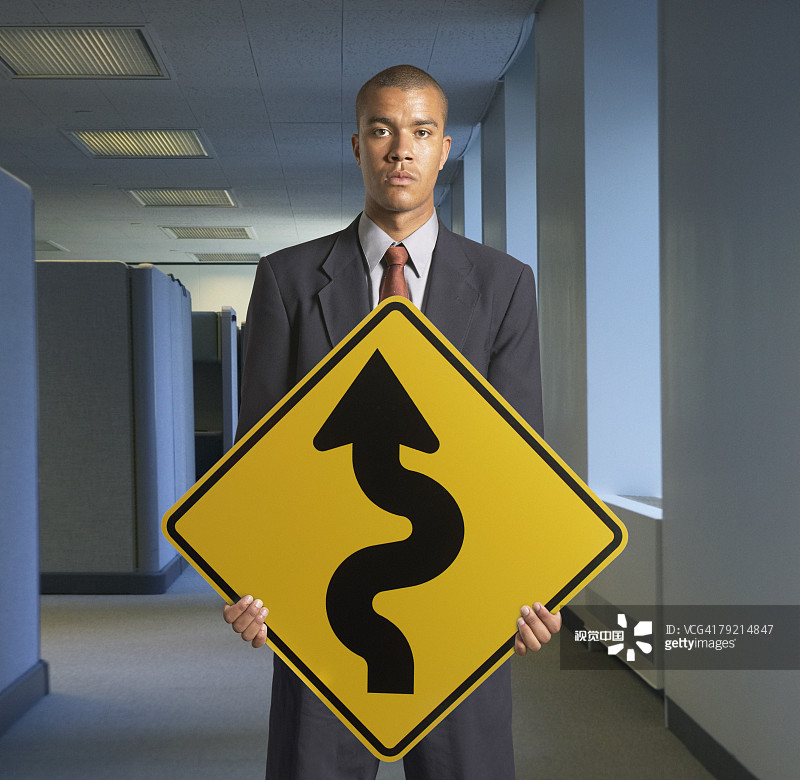 商人拿着前方弯道标志图片素材