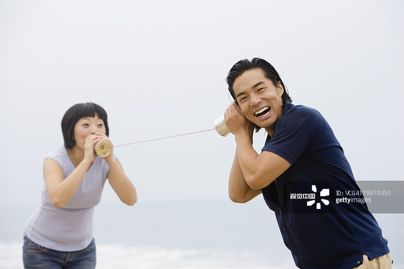 亚洲夫妇玩罐头和线电话图片素材