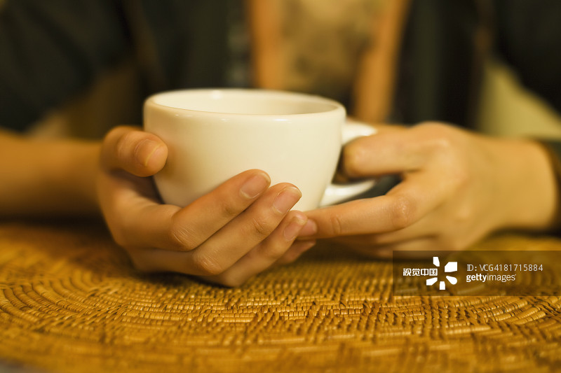 近距离的女人的手拿着茶杯图片素材