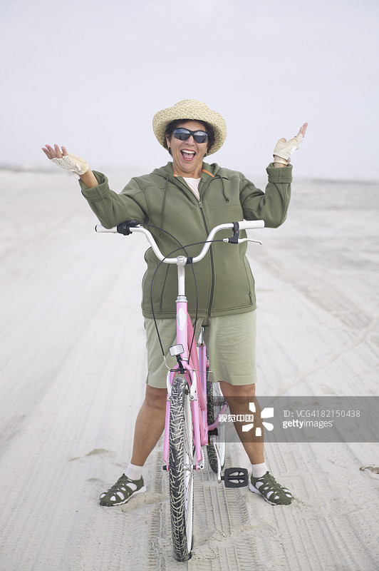 在海滩上骑自行车的老年妇女图片素材