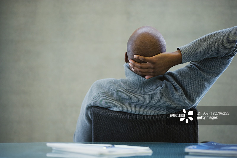 在办公室手背在脑后的非洲商人图片素材