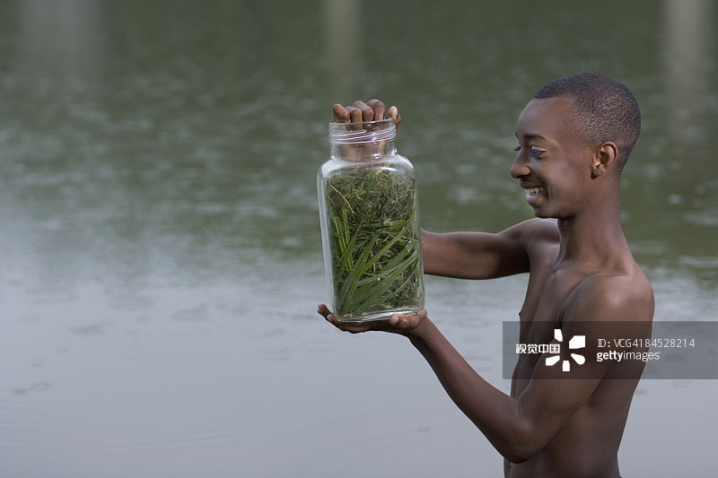 非洲男孩拿着昆虫罐图片素材