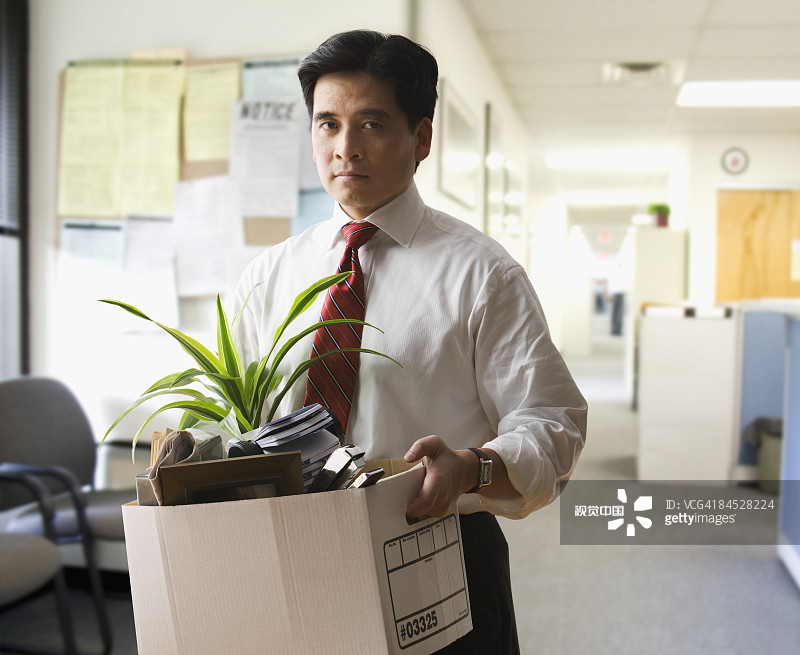 被解雇的中国商人抱着装有个人物品的箱子图片素材