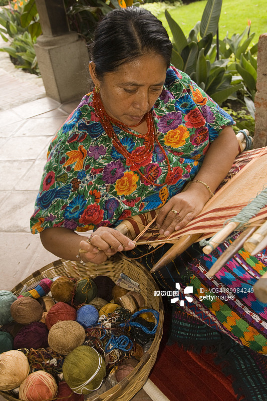 女人用传统腰带织布机编织图片素材